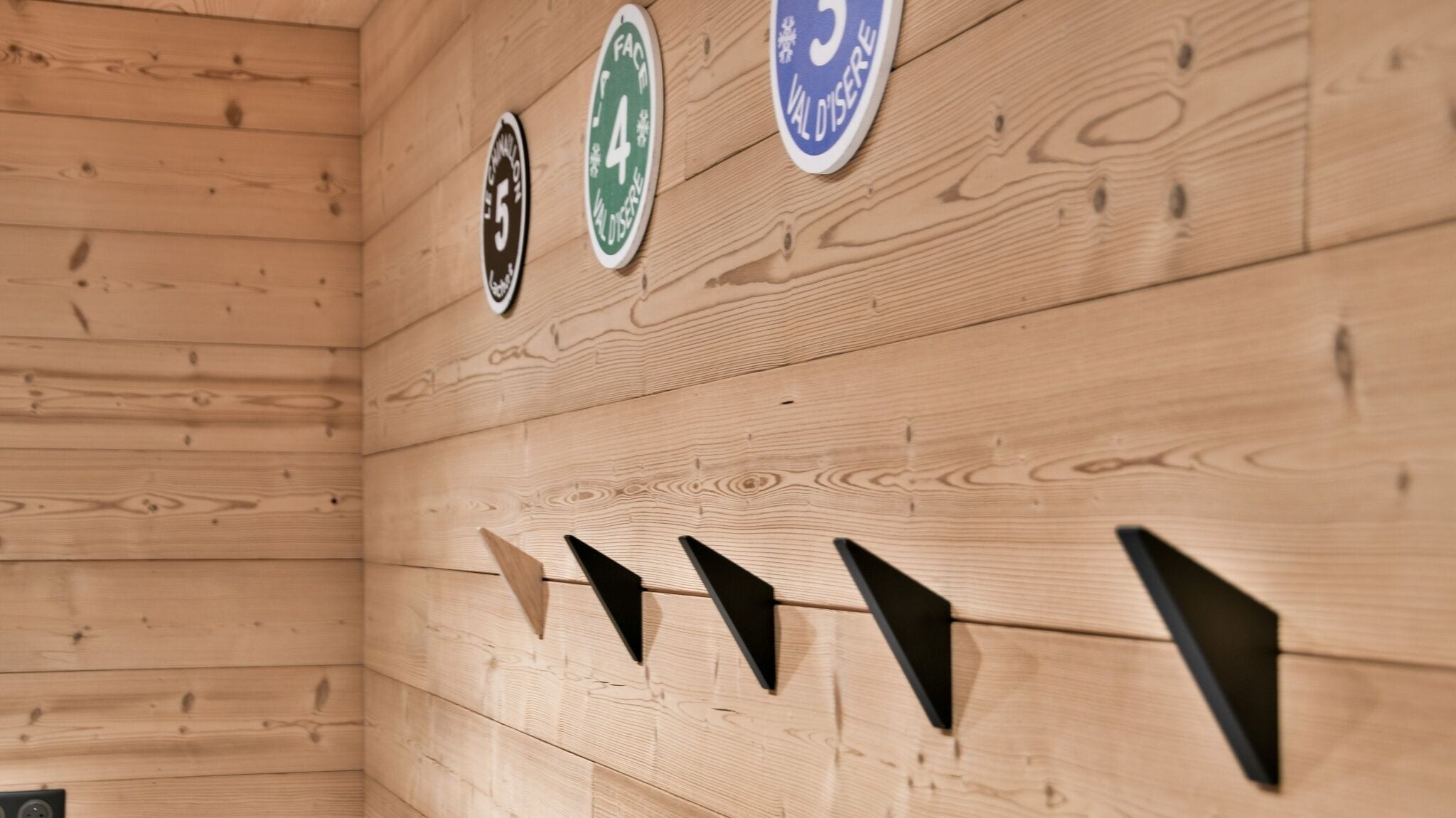 Un intérieur en bois avec trois panneaux accrochés au mur, chacun portant un numéro et un texte.