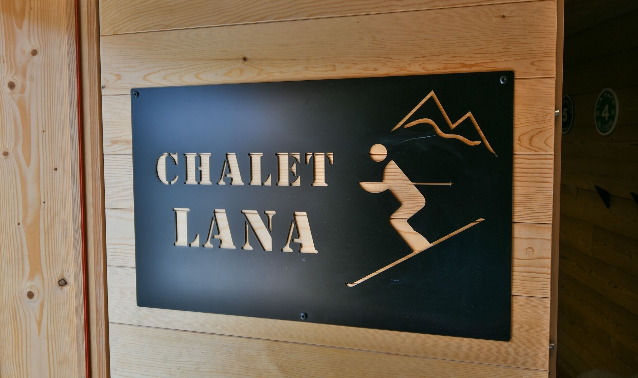 Un cartel con el texto "CHALET LANA" e ilustración de un esquiador.