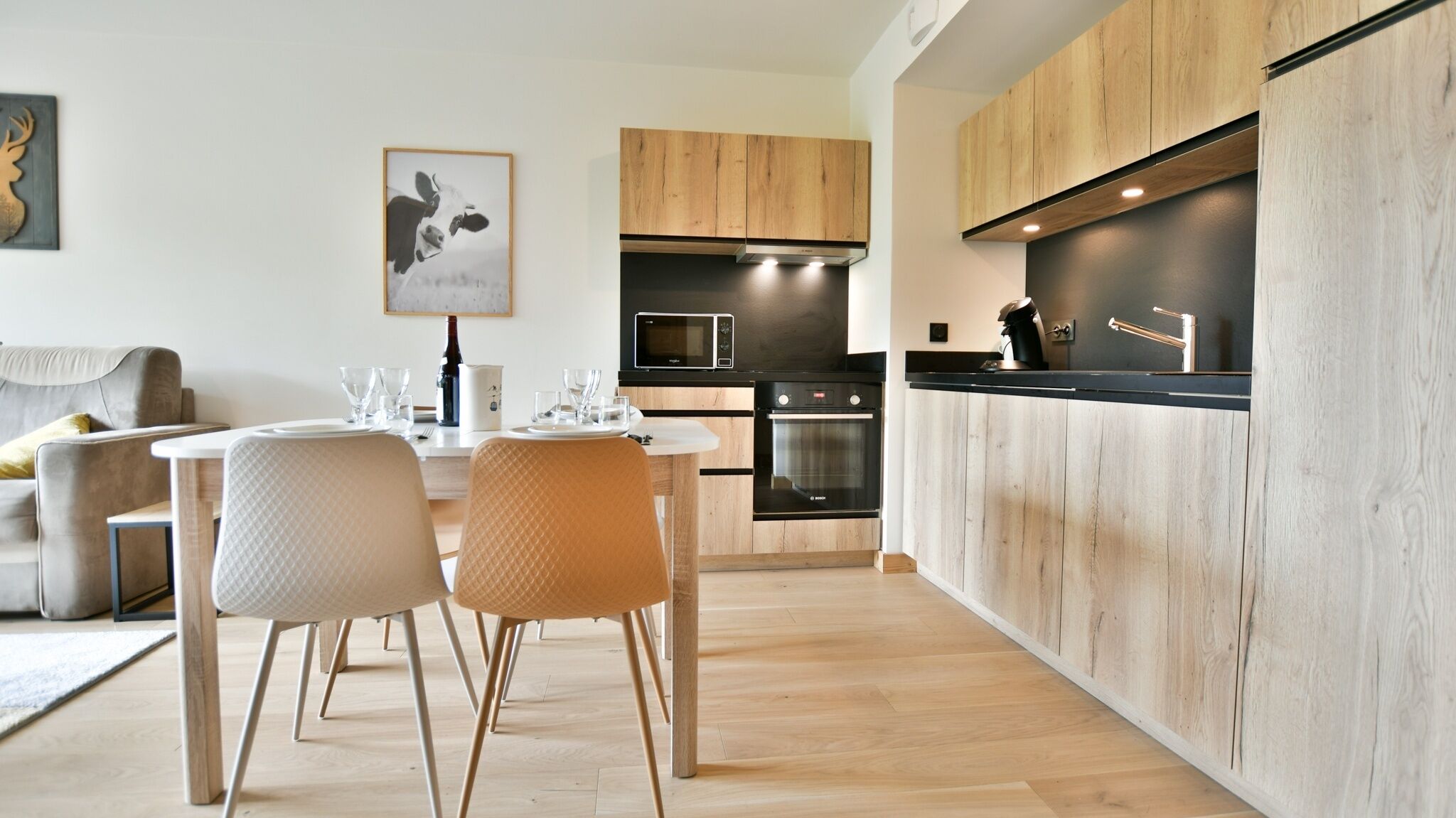 A modern kitchen with wooden cabinets, a built-in oven, and a microwave.