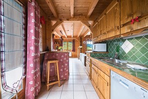 Una cocina de madera con salpicadero de azulejos, un fregadero y un lavavajillas.