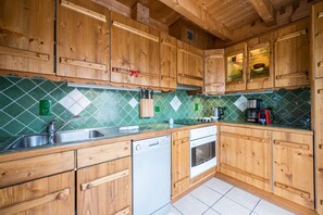 Una cocina con armarios de madera, lavavajillas y estufa.
