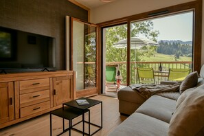Een moderne woonkamer met een televisie, een houten kast en een bank.