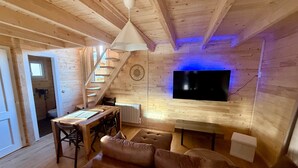 Un intérieur en bois comprenant un canapé, une table à manger et un téléviseur fixé au mur.