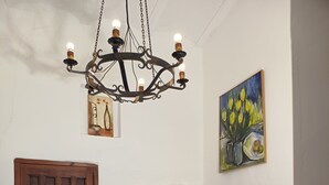 A dining area with a wooden table, chairs, and a chandelier. - El Oasis Morado (Lorca)