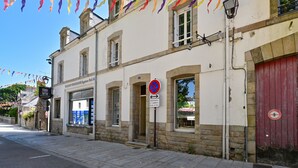 Un bâtiment avec une enseigne indiquant qu’il s’agit d’une pharmacie et un panneau interdisant le stationnement.