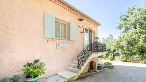 A building with a stone facade, a staircase with a wrought iron railing, and a sign indicating a restaurant. - Le Baiser du Soleil - Piscine Privée (Mirabel-aux-Baronnies)