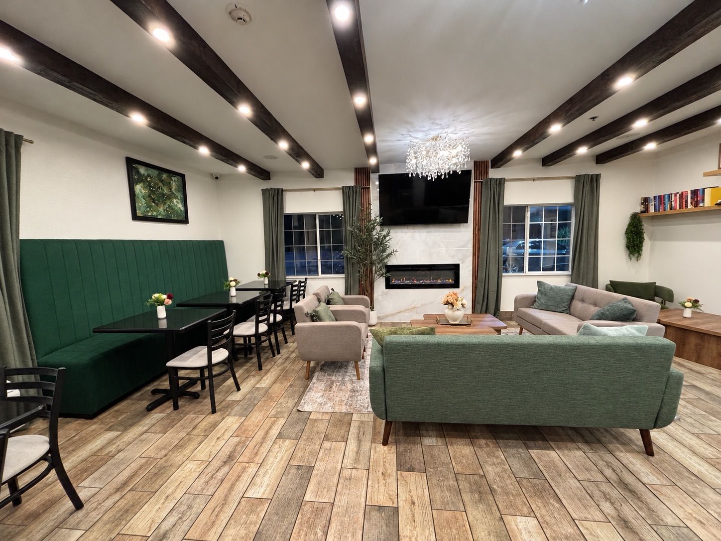 A modern living room with a green sofa, a dining area with a pool table, and a fireplace.