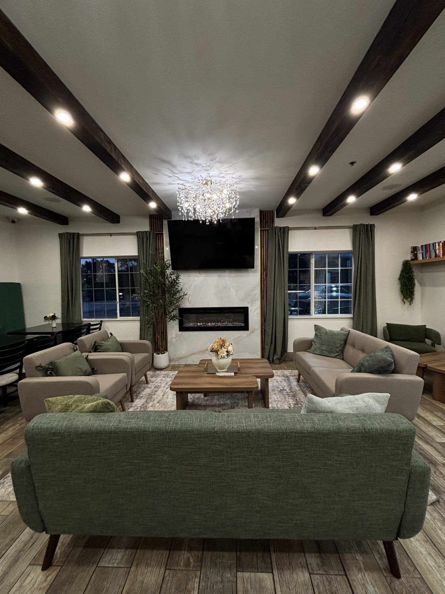 A modern living room with a large sofa, a coffee table, and a TV mounted on the wall.