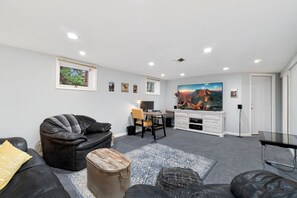 A modern living room with a leather sofa, a coffee table, and a TV.