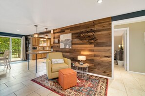 A modern living room with a sofa, ottoman, and a rug.