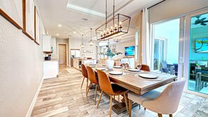 Un espace repas moderne avec une table en bois dressée pour quatre personnes, entourée de chaises.
