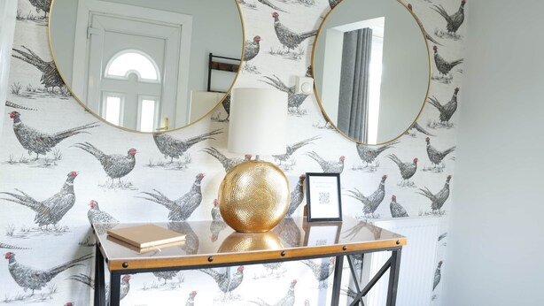 Una habitación con una mesa, dos espejos redondos, una lámpara y una esfera decorativa.