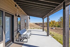 A covered patio with a bench and a door leading to a building. - Beartooth Mountain Lodge - Private hot tub  - $50 dollar with 3 night stay (Red Lodge)