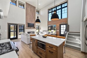 A modern kitchen with a central island, wooden cabinetry, and pendant lighting. - Beartooth Mountain Lodge - Private hot tub  - $50 dollar with 3 night stay (Red Lodge)