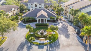 An aerial view of a residential area with a central circular driveway, a fountain, and a sign reading "The Avalon."
