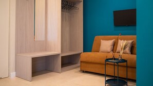 Una habitación moderna con un armario de madera, un sofá y una pequeña mesa.