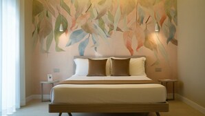 Un dormitorio moderno con una cama grande, dos mesitas de noche y un mural en la pared.