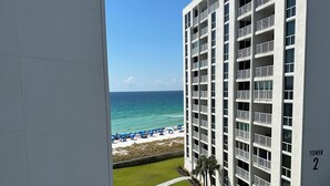 A modern building with multiple balconies, a well-maintained lawn, and a view of the beach. - Florida Sunshine Beachfront @ Shoreline Towers 3 br condo with beachfront views (Destin)