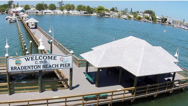 A pier with a sign reading "Welcome C.1921 Bradenton Beach Pier".