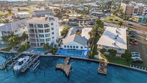 Luftaufnahme eines Küstenhotels mit mehreren Gebäuden, einer Marina und einem Schwimmbad.