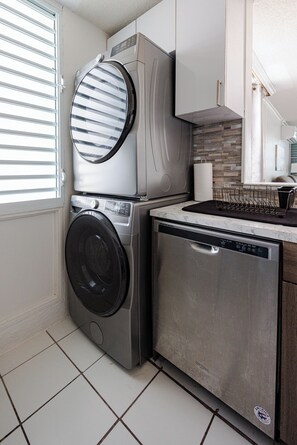 A compact kitchen with a washing machine, dishwasher, and a small countertop. - Ocean view 3BR/2BA condo in Fajardo PR. Washer dryer in unit (Fajardo)