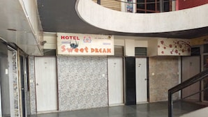 A hotel interior with a sign reading "HOTEL Sweet Dream" and a staircase leading to upper floors. - Hotel Sweet Dream (Rajkot)