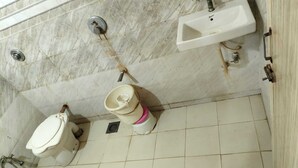 A bathroom with a toilet, bidet, and sink. - Hotel Sweet Dream (Rajkot)