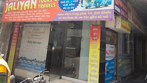 A hotel named 'Hotel Sweet Dream' with a signboard advertising tours and travels. - Hotel Sweet Dream (Rajkot)