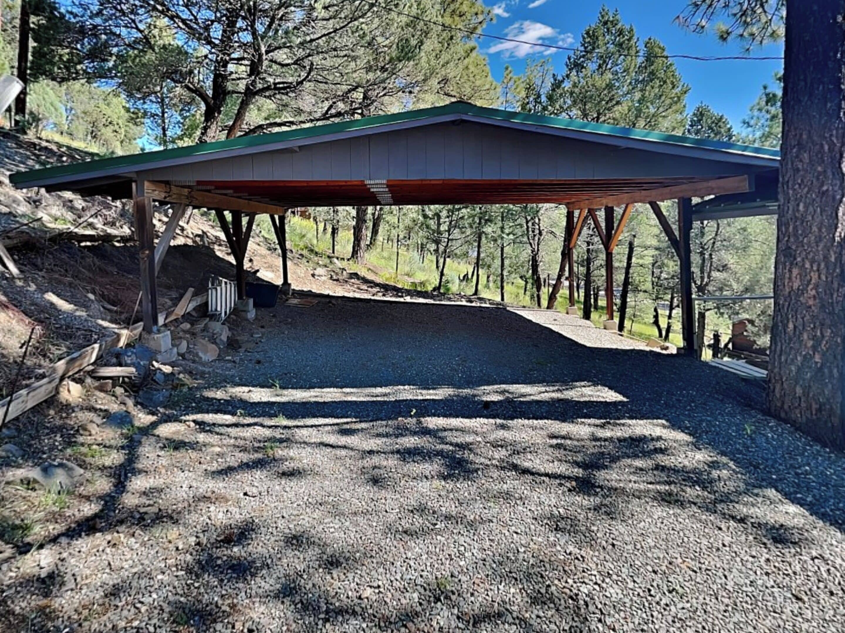 A covered outdoor area with a gravel path leading to a building.
