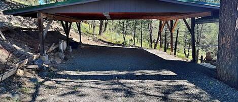 A covered outdoor area with a gravel path leading to a building.