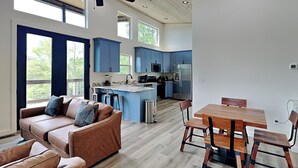 A spacious living room with a brown leather sofa and a wooden dining table with chairs. - Sunrise in the Cove (Sevierville)
