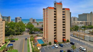 A high-rise hotel with a pool, parking, and a view of the ocean. - 2BR Condo in Myrtle Beach w/ Kitchen + Pool Access (Myrtle Beach)