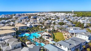 A coastal residential area with a large swimming pool, multiple buildings, and a water tower.