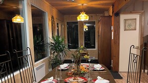 A dining area with a long wooden table, metal chairs, and a chandelier.