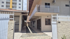 A residential building with a gated entrance, a covered walkway, and a balcony. - Fully Equipped Houses in a Condominium With a Pool, 110m From the Beach - Onis (Barra Velha)