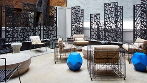 Ein moderner Außenbereich mit Sitzgelegenheiten, Metallmöbeln und geometrischen Mustern.