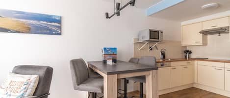A compact kitchen with a microwave, sink, and wooden cabinets.