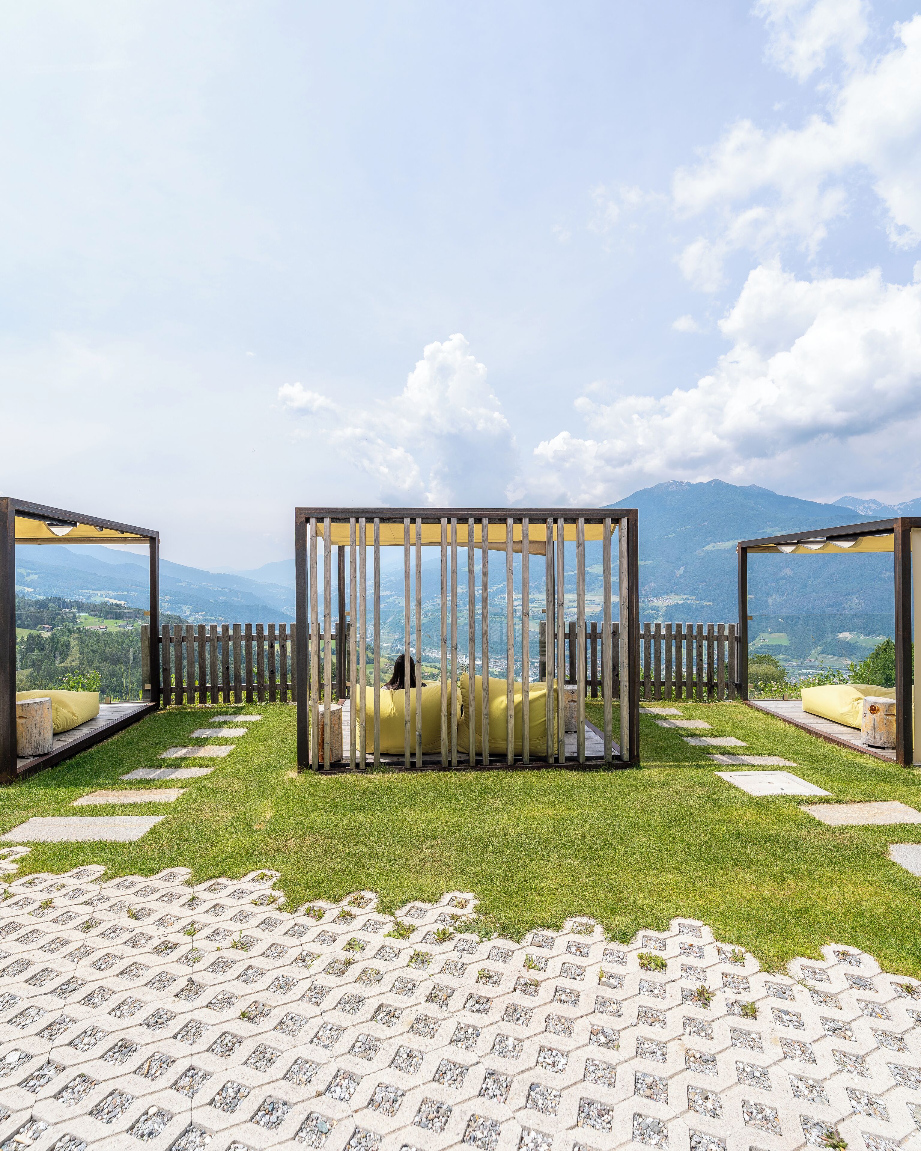 A gazebo with a view of mountains and a paved area with stepping stones.