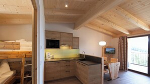 A compact kitchen with wooden cabinets, a built-in microwave, and a sink. - Aparthotel Bacher (Bressanone)