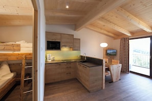 A compact kitchen with wooden cabinets, a built-in microwave, and a sink.
