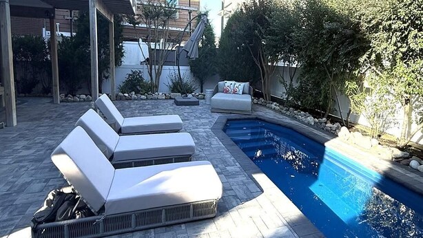 A pool area with lounge chairs and a small pool.