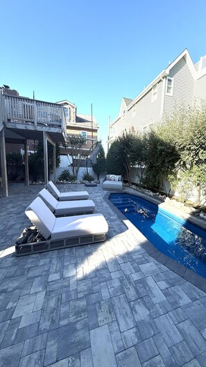 A pool area with lounge chairs and a small pool.