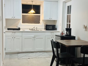 Réfrigérateur, micro-ondes, cafetière/bouilloire, tables à manger