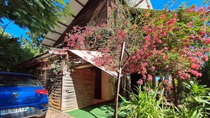 A blue Volkswagen T4D parked in front of a wooden structure with a green carpeted entrance.