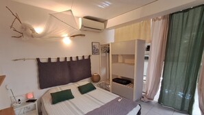 A bedroom with a bed, bedside tables, a wardrobe, and a window with curtains.