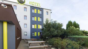 A B&B hotel with a modern design, outdoor seating, and a well-maintained garden.