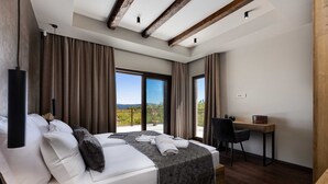 Une chambre d’hôtel moderne, dotée d’un grand lit, d’un bureau et offrant une vue sur l’extérieur.