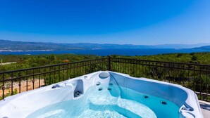 Un bain à remous offrant une vue dégagée sur un lac et des montagnes en arrière-plan.