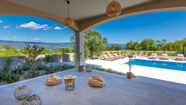 Un espace aménagé au bord de la piscine, avec des chaises longues, une piscine et une vue sur le paysage.