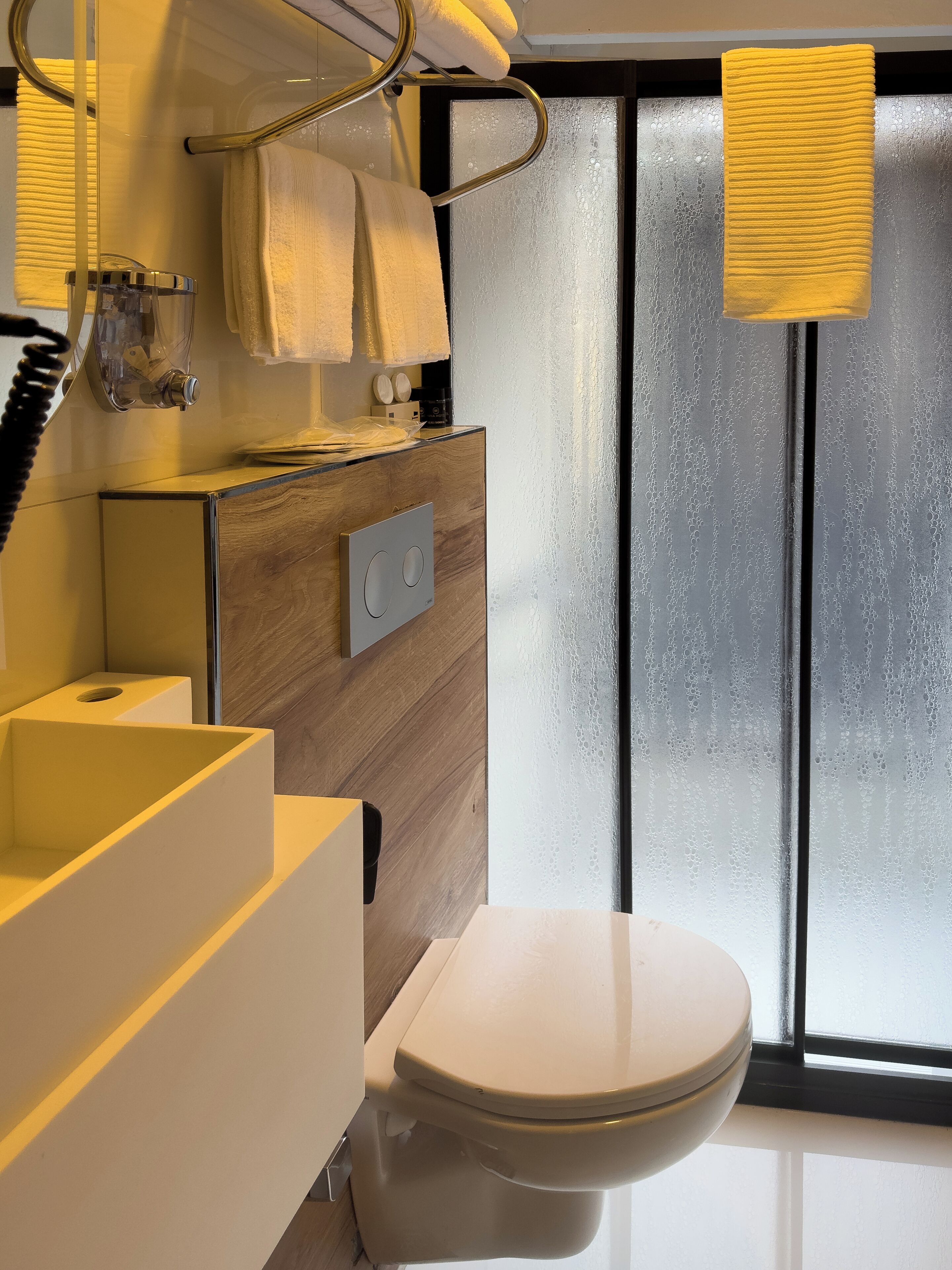 A modern bathroom with a toilet, a sink, and a mirror.